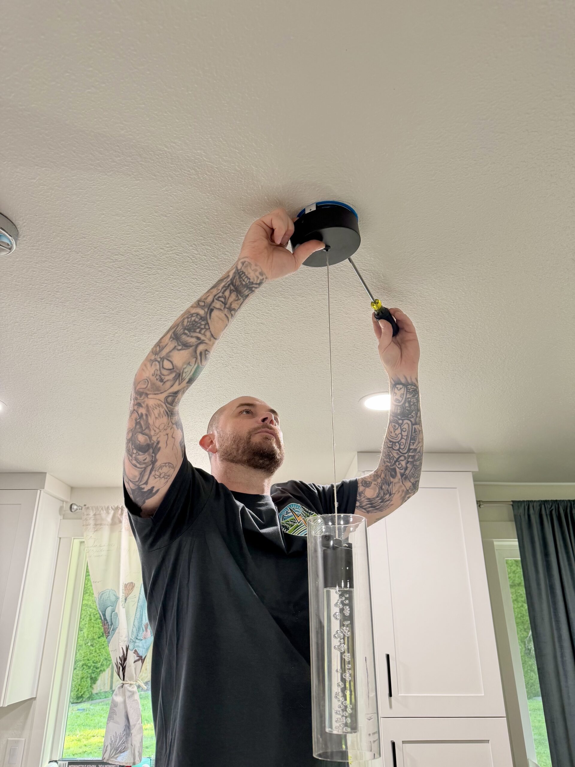oak-harbor-wa-electrician-lighting-installation-johnson-electrical-services Licensed electrician installing modern pendant lighting in a kitchen remodel in Oak Harbor, WA by Johnson Electrical Services.