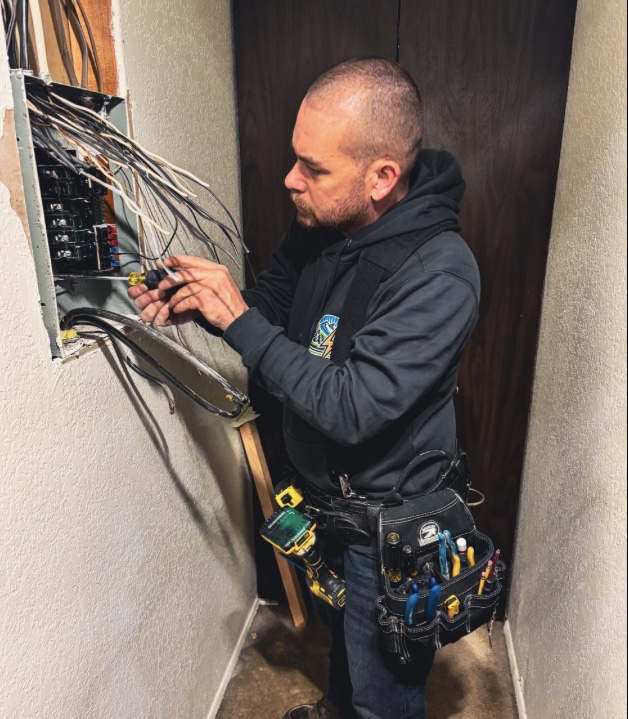 electrician-performing-electrical-repair-freeland Professional electrician troubleshooting an electrical issue in Freeland, Washington.