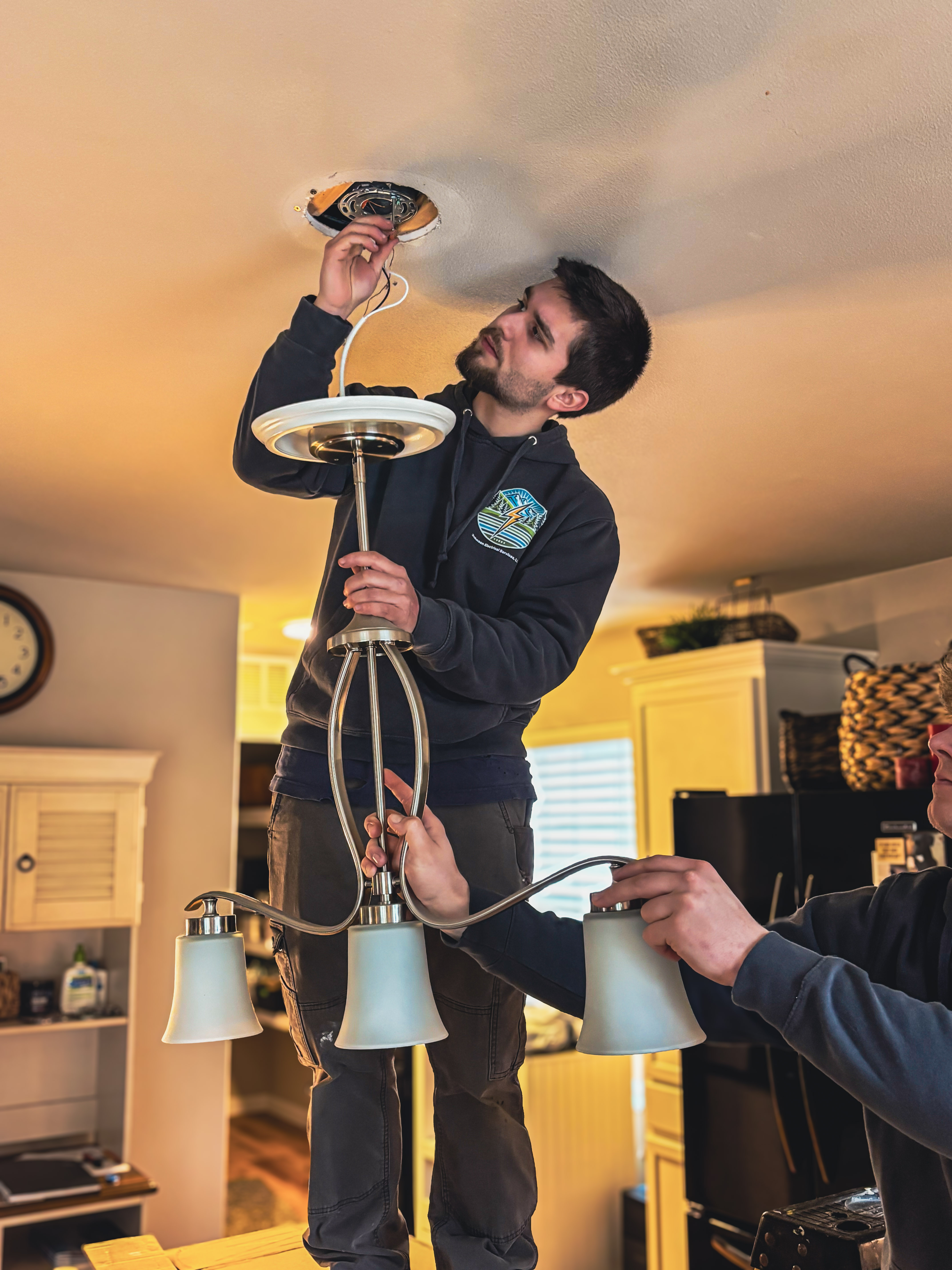 Licensed electrician installing new light fixtures in Skagit County, WA, improving home lighting, functionality, and visual appeal.