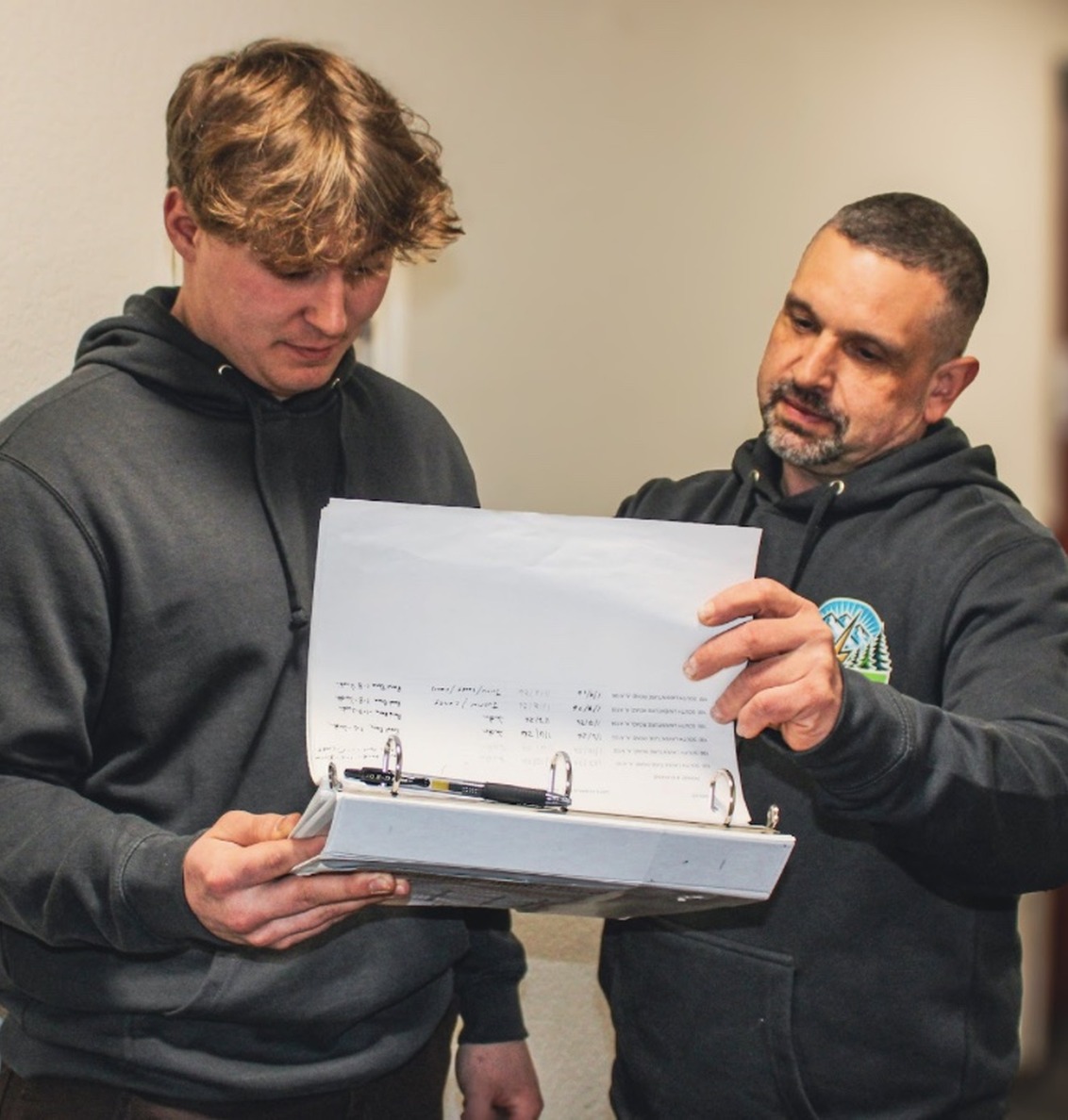 johnson-electrical-services-electrician-training-concrete-wa Johnson Electrical Services electrician reviewing project plans with an apprentice in Concrete, WA.